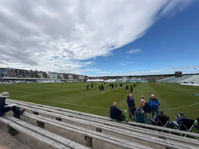 Players on the field and spectators taking their seats ahead of play at North Marin Road