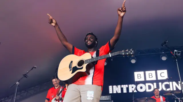 Myles Smith on stage at Big Weekend in Luton wearing a Hatters shirt
