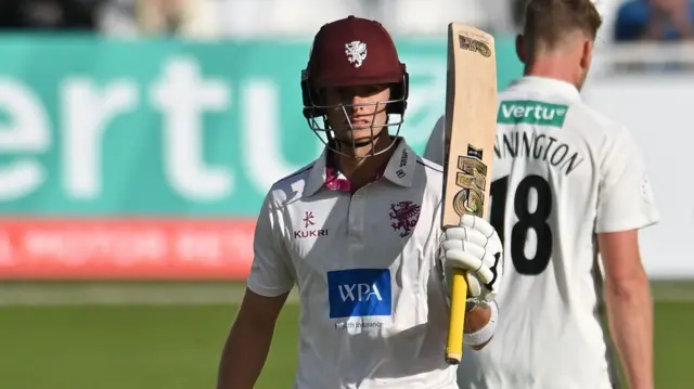Archie Vaughan raises his bat to celebrate 50