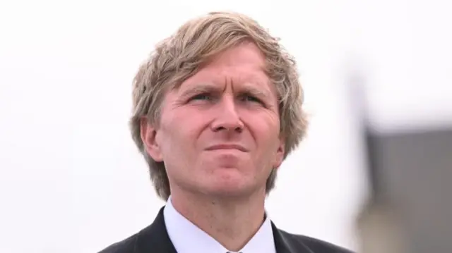 Elbridge Colby in a dark suit and light shirt