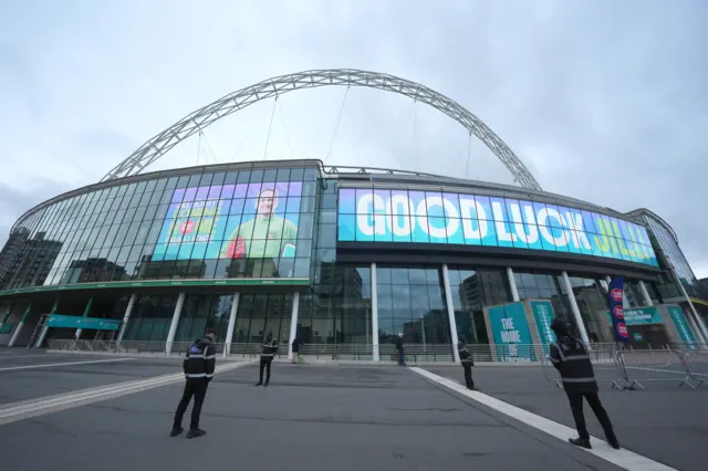 Wembley Stadium with an image of Jill Scott on it and the message Good Luck Jill in white and green writing on a blue background. The Wembley arch is seen above the banner