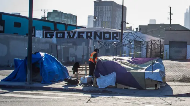 A man experiencing homelessness stands outside a tent in the Skid Row area of downtown Los Angeles on June 11, 2026, the eve of the World Cup opening match in the US. America's second biggest city will host eight games in the World Cup but faces even bigger global scrutiny in 2028 when the Olympics come to town, bringing athletes and fans from all over the world. Visitors to Los Angeles are frequently struck by the staggering levels of homelessness in a city that also has pockets of astonishing wealth.