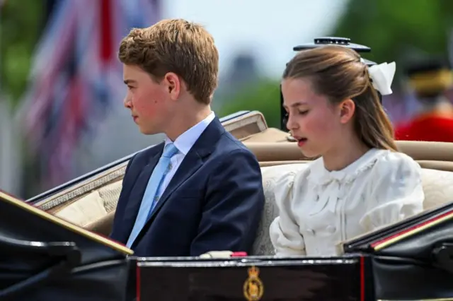 Prince George and Princess Charlotte sit in a horse-drawn carriage