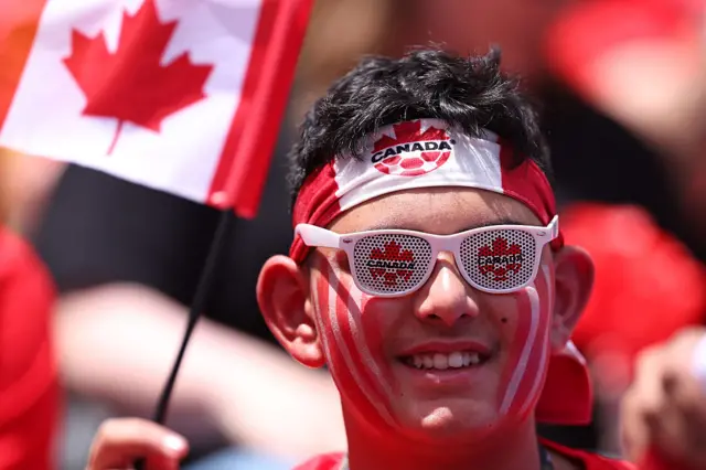A person wearing a Canada flag headband and sunglasses