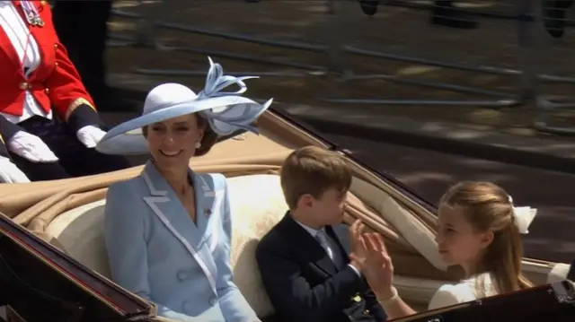 The Princess of Wales smiles as she travels in a carriage, while Prince Louis and Princess Charlotte wave