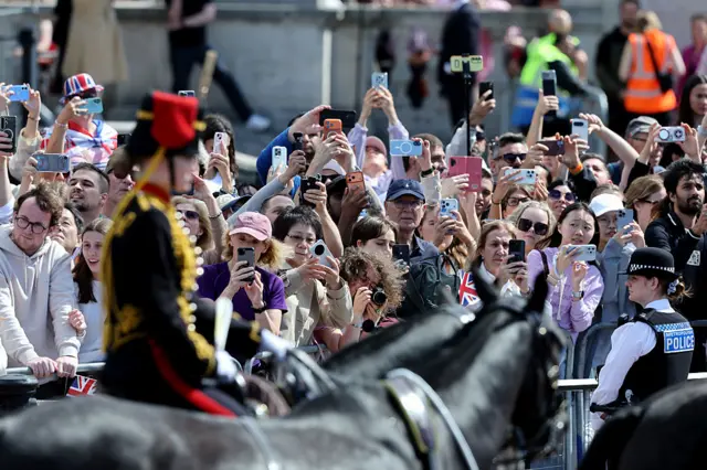 Crowds take photos of a member of the Royal House Artillery riding on horseback during the parade.