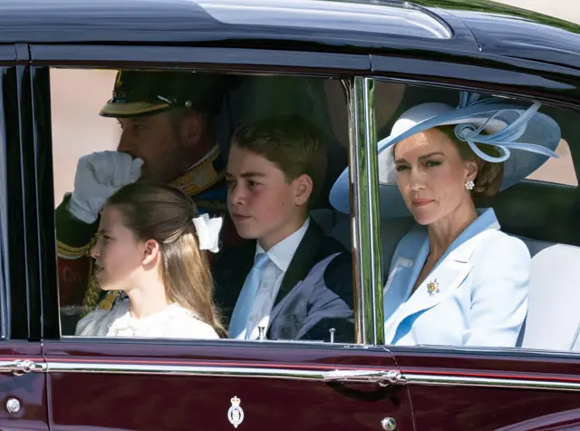 The Prince and Princess of Wales in a car, with Prince George and Princess Charlotte also visible.