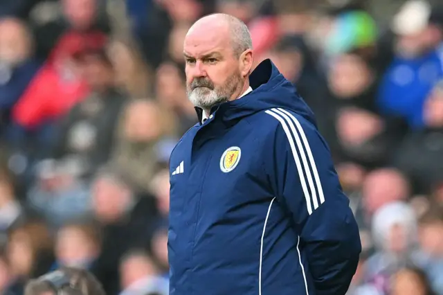 Steve Clarke wearing a navy blue coat with a Scotland badge on the chest