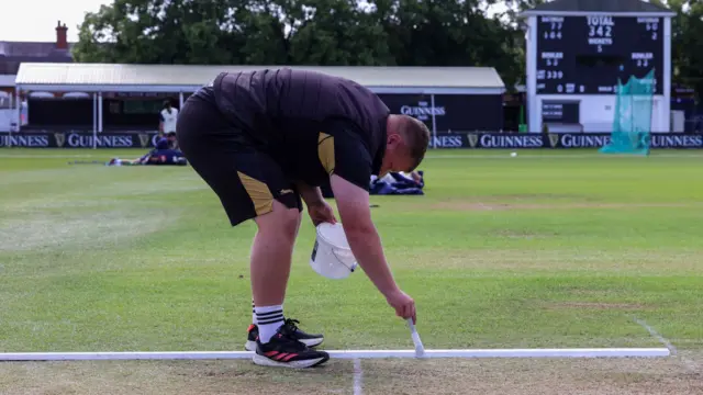 A member of the Leicestershire groundstaff marks the creases ready for day two between Leics and Essex