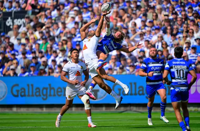 Olly Woodburn of Exeter Chiefs goes up for the high ball with Tom de Glanville of Bath