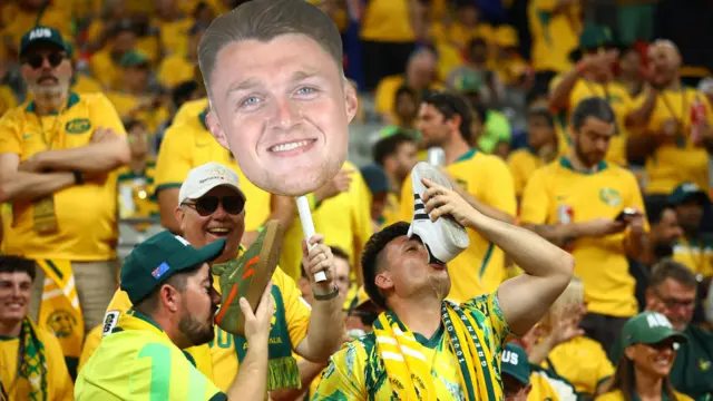 Australia fans drink beer out of a shoe in the stands before the match