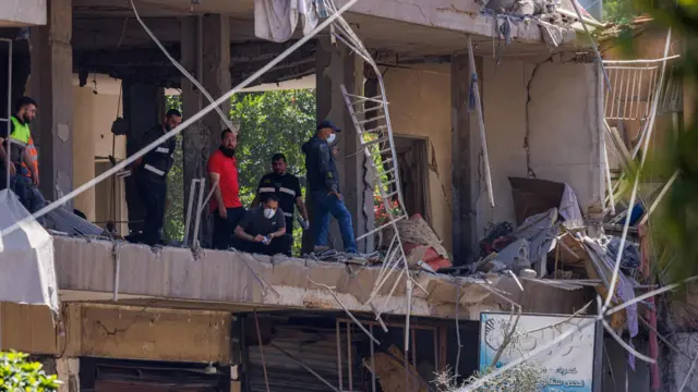 Police officers and emergency personnel work at the site of an Israeli strike on the southern suburbs of Beirut, Lebanon, June 14, 202