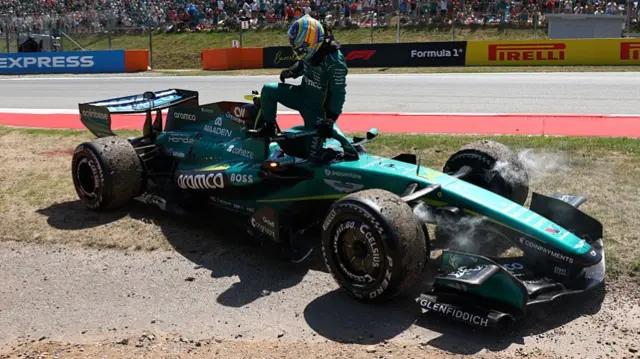 Fernando Alonso getting out of his car after retiring from the Barcelona GP