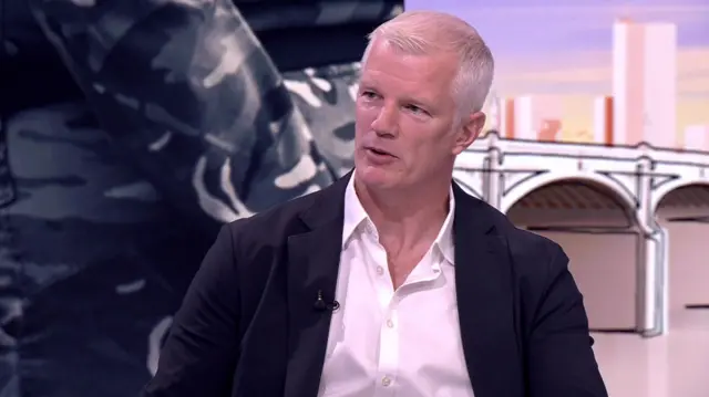 Al Carns is pictured in the Laura Kuenssberg studio, wearing a dark jacket and open white shirt.