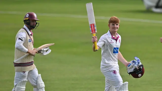 Thomas Rew celebrates his 127 not out with his bat raised