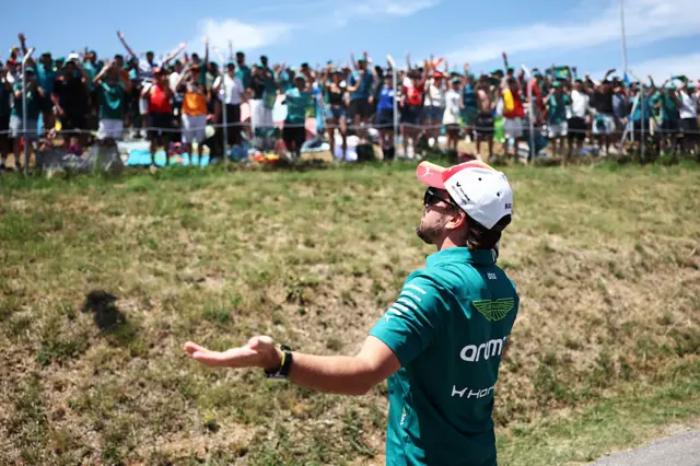 Fernando Alonso holds his arms out in front of the Spanish crowd in Barcelona