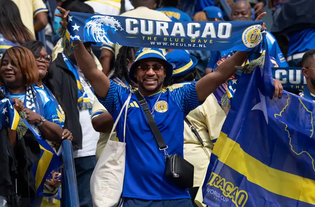 Curacao fan holding up a scarf