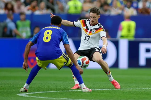Florian Wirtz of Germany and Livano Comenecia of Curacao battle for the ball