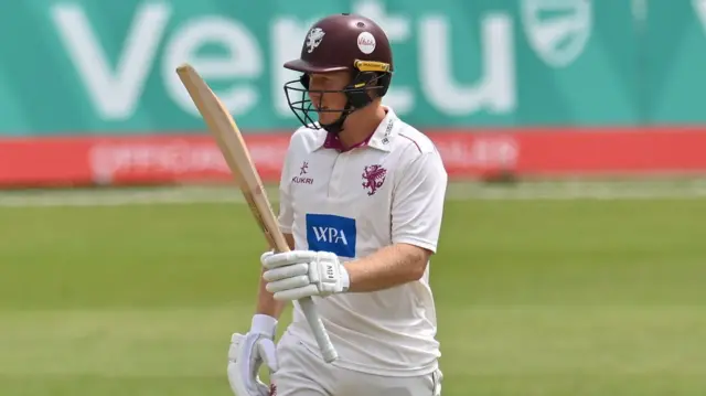 James Rew raises his bat after getting 50