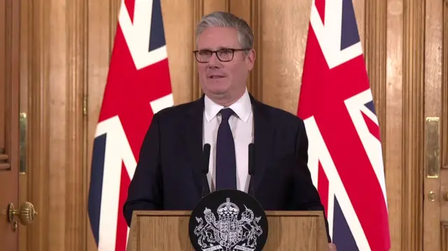 Keir Starmer, dressed in suit at podium in Downing Street