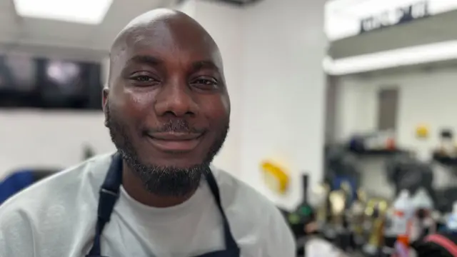 A smiling man inside a barbers