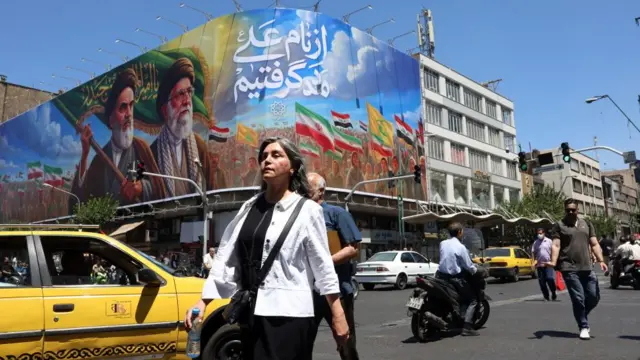 Iranians walk past a billboard of the late Iranian supreme leaders Ayatollah Ruhollah Khomeini and Ayatollah Ali Khamenei on a street in Tehran, Iran, 15 June 2026.