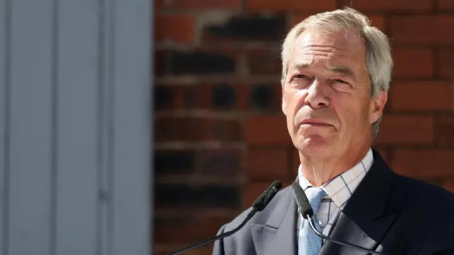 Nigel Farage looking outward at the camera while speaking at a news conference