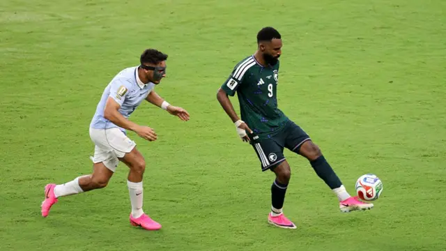 Feras Al-Buraikan controls the ball against Sebastian Caceres