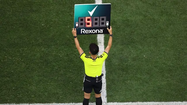 The fourth official holds up the board