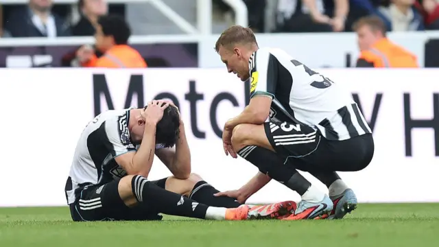 Tino Livramento of Newcastle United is consoled by teammate Dan Burn following an injury during the Premier League match between Newcastle United and Arsenal at St James' Park on September 28, 2025 in Newcastle upon Tyne, England.