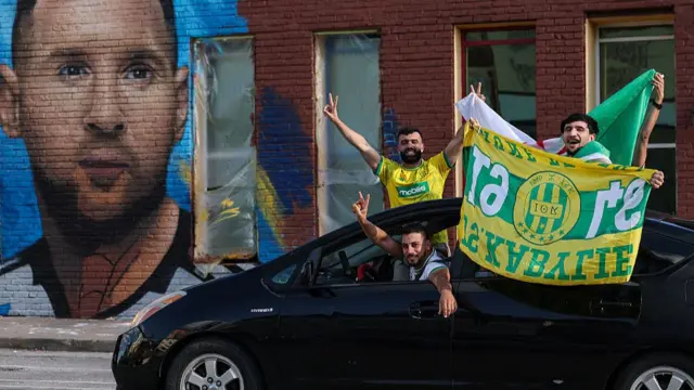 Algerian fans drive past a Lionel Messi mural along Main Street and East 20th Street ahead of Tuesday's Group J match between Argentina and Algeria on June 15, 2026 in Kansas City, Missouri