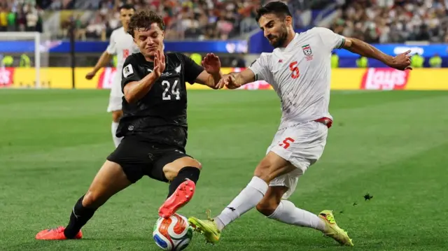 New Zealand's Callan Elliot and Iran's Milad Mohammadi both go for the ball