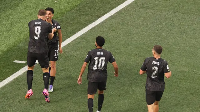 Elijah Just celebrates with teammates after scoring his team's first goal
