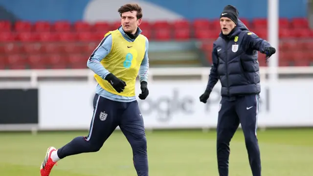 Harry Maguire of England runs as Thomas Tuchel, Head Coach of England, reacts during a training session at St Georges Park on March 25, 2026 in Burton-upon-Trent, England