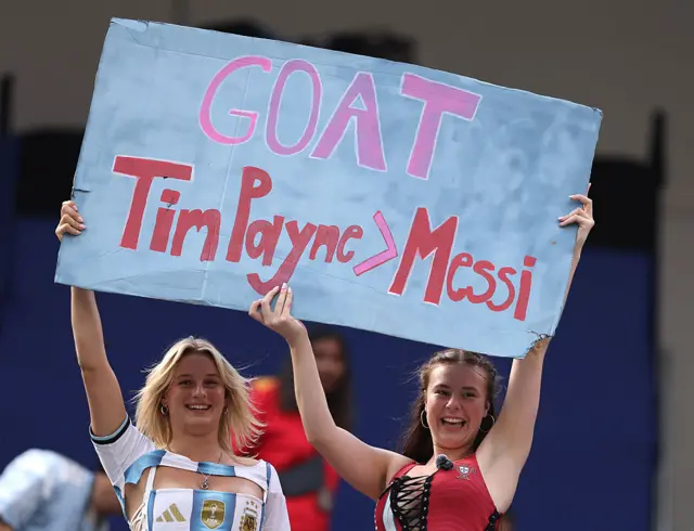 Fans hold poster saying Tim Payne > Messi