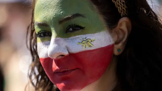 A woman with her face painted joins others as they protest against the Iranian regime outside Los Angeles Stadium (SoFi Stadium) ahead of the 2026 World Cup football tournament match between Iran and New Zealand in Inglewood, California, on June 15, 2026.