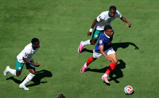 France's Kylian Mbappe in action with Senegal's Nicolas Jackson and Lamine Camara
