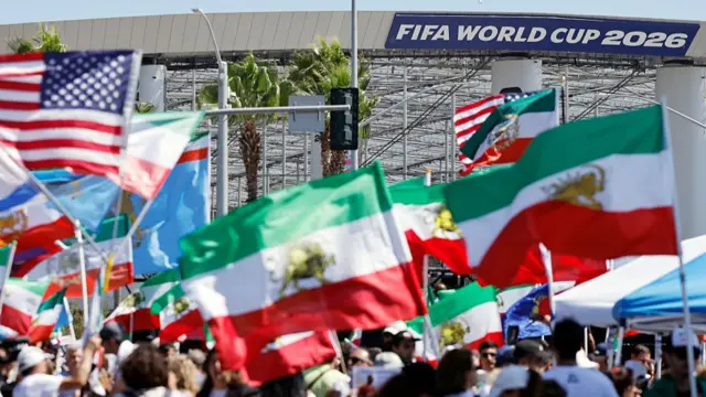 Protestors demonstrate against the Islamic Republic of Iran, while holding pre-revolutionary Iranian flags and other flags, outside Los Angeles Stadium ahead of the Iranian national soccer team’s World Cup match against New Zealand on June 15, 2026 in Los Angeles, California