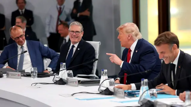 German Chancellor Friedrich Merz, British Prime Minister Keir Starmer, U.S. President Donald Trump and President of France Emmanuel Macron talking around a table.