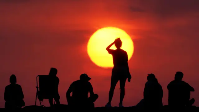 People turning out to watch the sunrise at Cullercoats Bay, North Tyneside.
