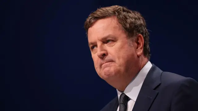 Mel Stride looks stern as he delivers a speech in October 2025. He is wearing a dark suit and is against a dark blue background