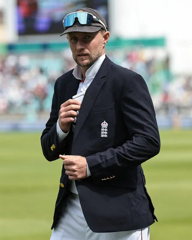 Joe Root putting a piece of paper into the inside pocket of his blazer, as he prepares to captain England before the match