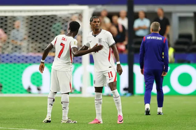 Bukayo Saka #7 of England hugs teammate Marcus Rashford