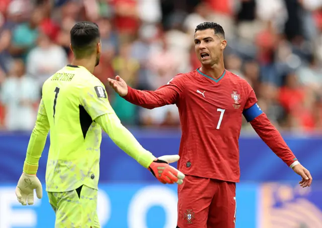 Cristiano Ronaldo #7 of Portugal reacts with Diogo Costa #1