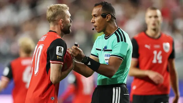 Referee Dahane Beida speaks to Konrad Laime