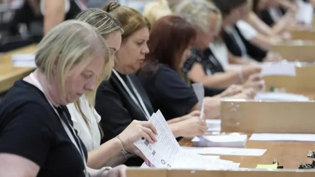 A row of women begin counting votes in the Makerfield by-election