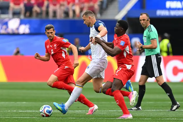 Edin Dzeko (C) runs with the ball