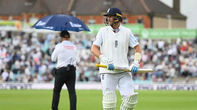 Joe Root walks off in the rain