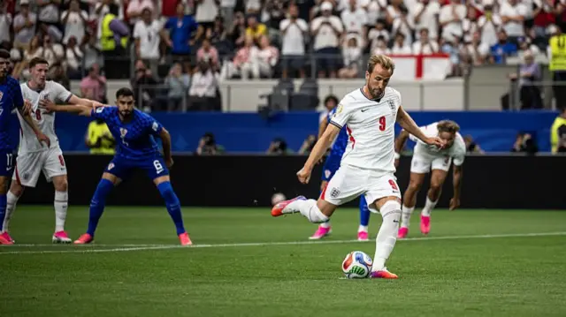 Harry Kane of England shoots a penalty kick to score his team's first goal