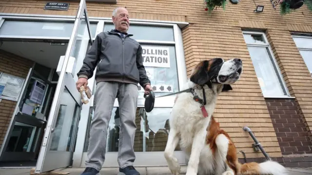 A voter and their St Bernard dog called Indie at a polling station in Wigan